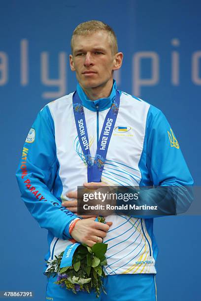 Gold medalist Grygorii Vovchynskyi of Ukraine covers his medal at the medal ceremony for the Men's 15km Standing Biathlon on day eight of the Sochi...