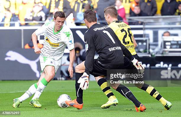 Max Kruse of Moenchengladbach is on his way against goalkeeper Roman Weidenfeller and Lukasz Piszczek of Dortmund to score his teams second goal...