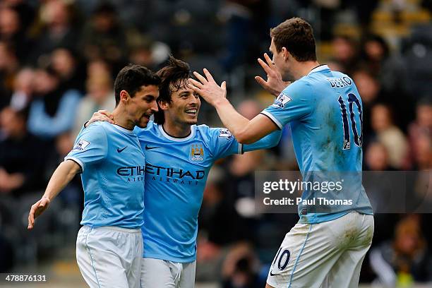 Edin Dzeko of Manchester City celebrates his goal with team mates Jesus Navas and David Silva during the Barclays Premier League match between Hull...