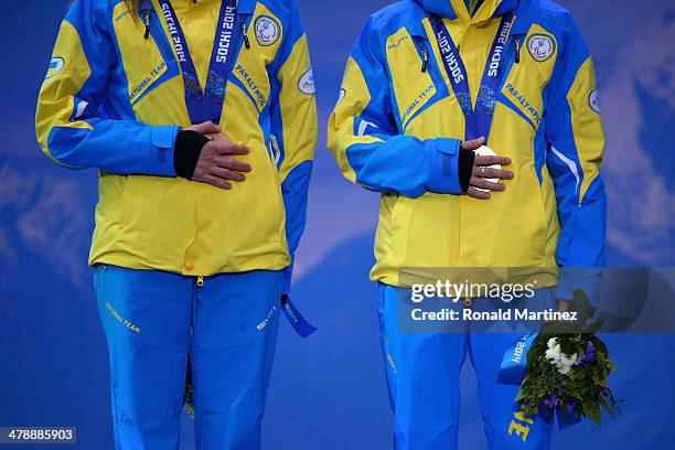 Bronze medalists guide Lada Nesterenko and Oksana Shyshkova of the Ukraine cover their medals at the medal ceremony for the the Women's 12.5km...