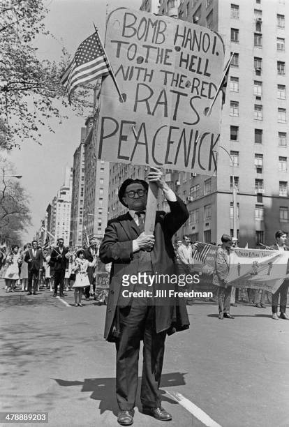 Man attends a Loyalty Day Parade in New York City holding a placard which reads 'Bomb Hanoi. To the Hell with the Red Rats Peacenick' , 2nd May 1967....