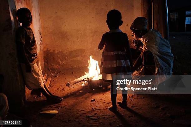 Homeless family cooks their dinner on an open fire in the street on June 28, 2015 in Bujumbura, Burundi. The head of BurundiÕs influential rights...