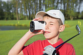 boy golfer watching into rangefinder