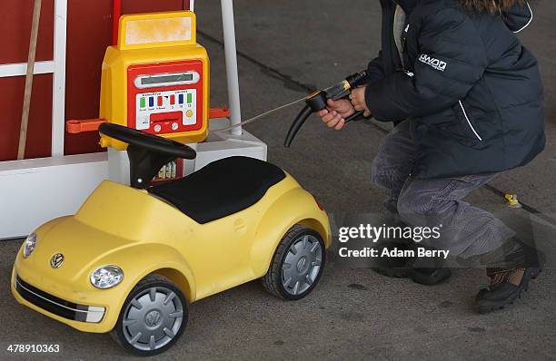Child pretends to put fuel into a toy Volkswagen Beetle at the Electric Mobility Week , a public Volkswagen event at the former Tempelhof airport, on...