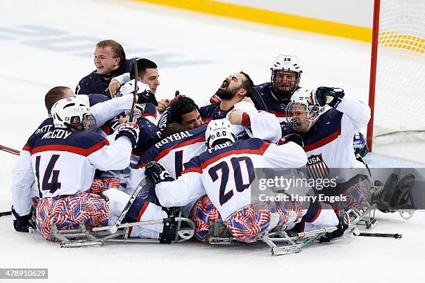 The USA team celebrate winning the Ice Sledge Hockey Gold Medal match between Russia and USA at the Shayba Arena during day eight of the 2014...