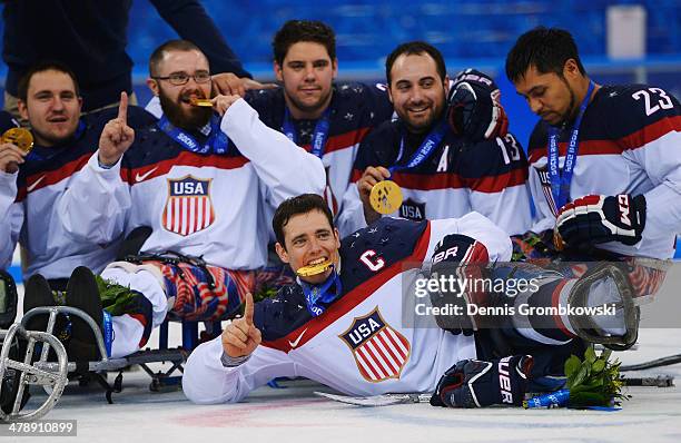 Andy Yohe of the United States poses with team mates after winning the gold medal in the Ice Sledge Hockey Gold Medal game between the United States...