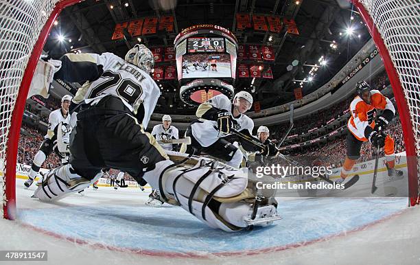 Marc-Andre Fleury of the Pittsburgh Penguins slides across his crease as teammte Olli Maatta defends against Wayne Simmonds of the Philadelphia...