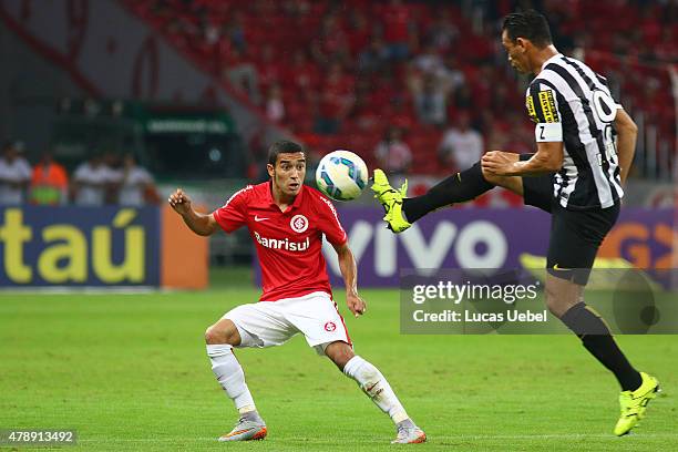 Willian of Internacional battles for the ball against Ricardo Oliveira of Santos during the match between Internacional and Santos as part of...