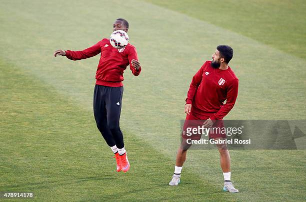 Luis Advincula of Peru controls the ball next to Josepmir Ballon of Peru during a field scouting prior to the semi final match against Chile at...