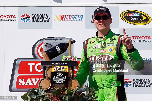 Kyle Busch, driver of the M&M's Crispy Toyota, poses with the trophy after winning the NASCAR Sprint Cup Series Toyota/Save Mart 350 at Sonoma...
