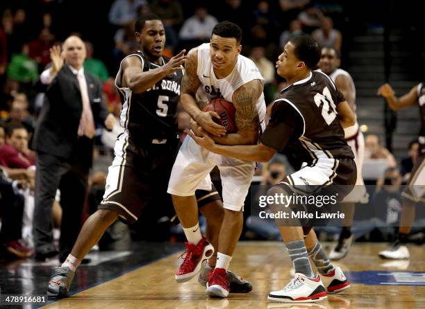 Chris Wilson of the Saint Joseph's Hawks fights for the ball with Jordan Gathers and Dion Wright of the St. Bonaventure Bonnies in the second half...