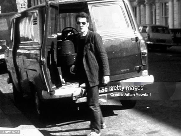 Frame from a Super-8 film of musician Joe Strummer , of English pub rock group The 101ers, loading a van outside his squat in Orsett Terrace, London...