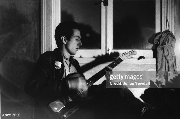 Joe Strummer of The Clash, practices by lamp-light at a squat in a disused ice cream factory in Foscote Mews, London, W9, 1976. It was here that...