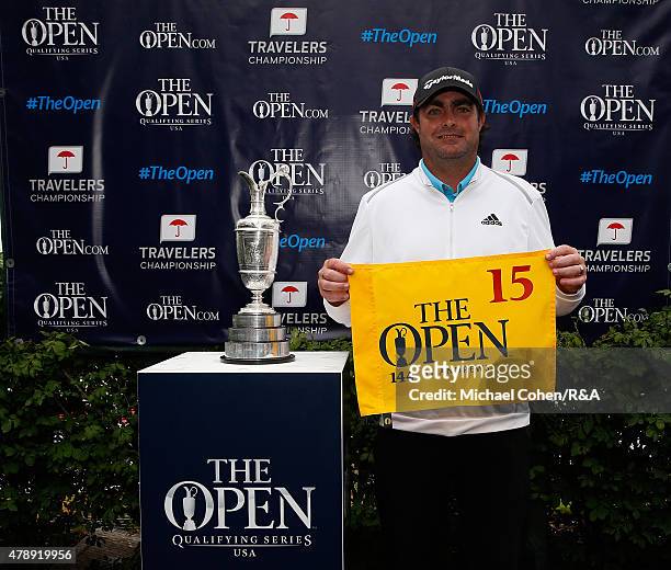 Steven Bowditch of Australia holds a hole flag and stands next to the Open Championship Trophy after qualifying for the Open Championship during the...