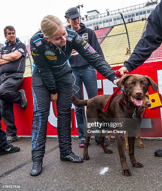 Christina Nielsen pats a dog during the fan walk before the Sahlen's Six Hours of the Glen at Watkins Glen International on June 28, 2015 in Watkins...