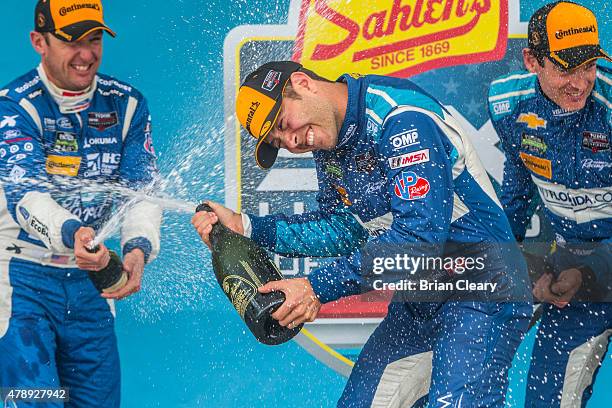 Michael Valiante celebrates with champagne after winning the Sahlen's Six Hours of the Glen at Watkins Glen International on June 28, 2015 in Watkins...