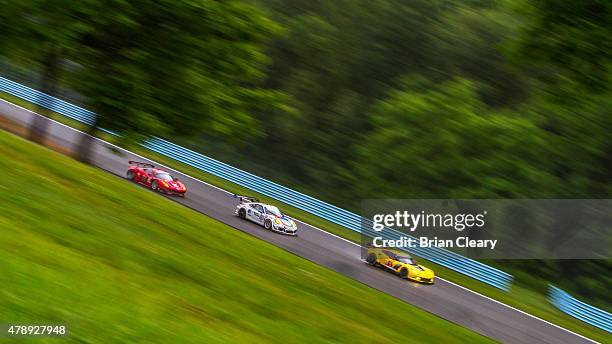 Pack of cars races in the rain during the Sahlen's Six Hours of the Glen at Watkins Glen International on June 28, 2015 in Watkins Glen, New York.