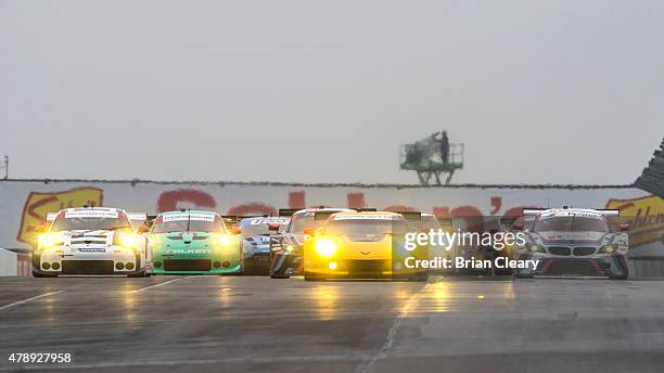 Cars race to turn one at the start of the Sahlen's Six Hours of the Glen at Watkins Glen International on June 28, 2015 in Watkins Glen, New York.