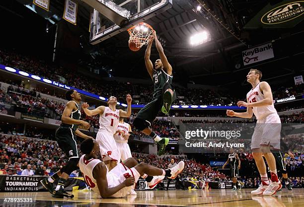 Adreian Payne of the Michigan State Spartans dunks the ball over Nigel Hayes of the Wisconsin Badgers who falls to the floor during the first half of...