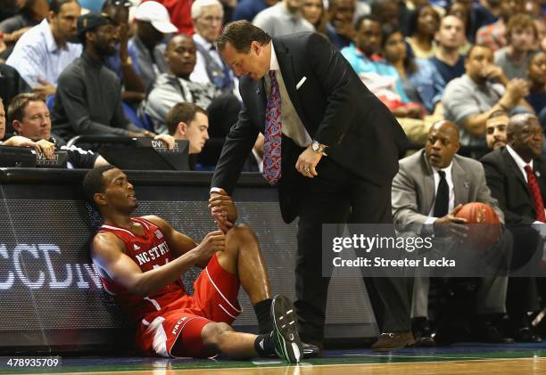 Head coach Mark Gottfried of the North Carolina State Wolfpack helps up his player T.J. Warren against the Duke Blue Devils during the semifinals of...