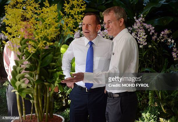 Australia's Prime Minister Tony Abbott speaks with Singapore's National Parks deputy director, David Middleton , during a visit to the National...