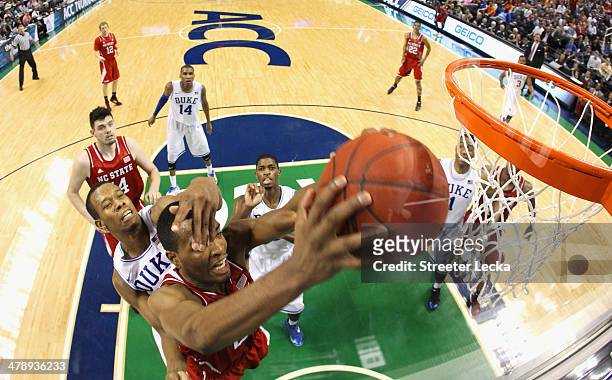 Warren of the North Carolina State Wolfpack is hit in the face by Rodney Hood of the Duke Blue Devils during the semifinals of the 2014 Men's ACC...
