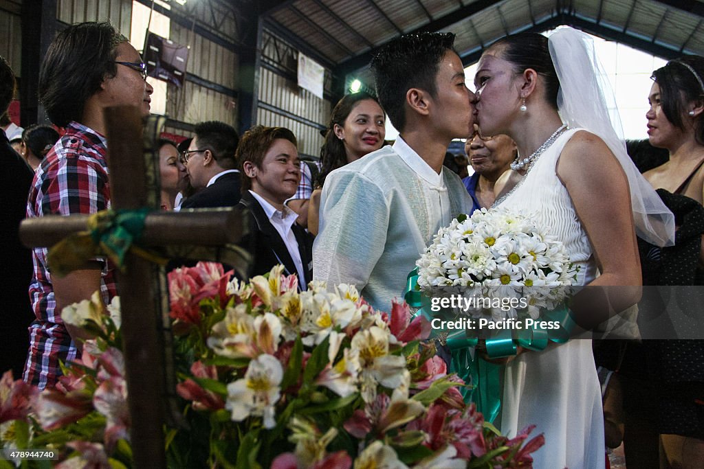 A couple kiss as their wedding witnesses stand around them...