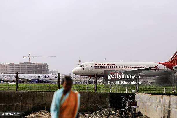 An Airbus SAS A319 aircraft operated by Air India Ltd. Taxies in front of an aircraft operated by IndiGo at Chhatrapati Shivaji International Airport...