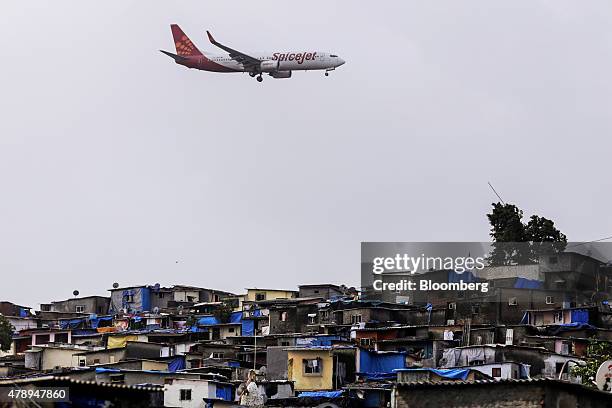 Boeing Co. 737 aircraft operated by SpiceJet Ltd. Flies over slum Housing as it approaches to land at Chhatrapati Shivaji International Airport in...