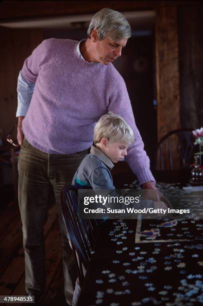 At his summer home, American writer and journalist George Plimpton and his son, Taylor Ames Plimpton, work together on a jigsaw puzzle, Wainscott,...