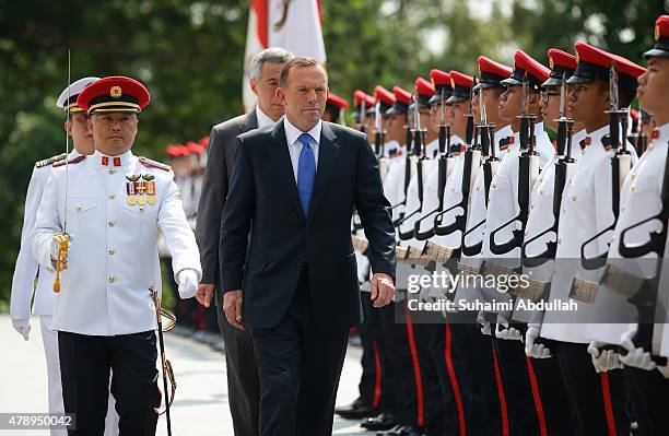 Australian Prime Minister Tony Abbott inspects the guard of honour during the official welcome ceremony accompanied by Singapore Prime Minister Lee...