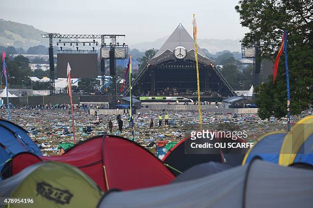 Tents are pictured against a backdrop of discarded litter at the end of the Glastonbury Festival of Music and Performing Arts on Worthy Farm near the...