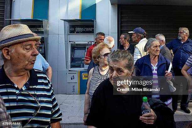 Pensioners stand outside of a branch of the National Bank of Greece hoping to draw their pensions on June 29, 2015 in Athens, Greece. Greece closed...