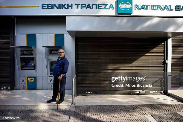 Pensioner stands outside of a branch of the National Bank of Greece hoping to draw his pension on June 29, 2015 in Athens, Greece. Greece closed its...