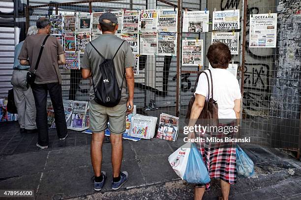 People read the headlines of daily newspapers after Greece closed its banks on June 29, 2015 in Athens, Greece. Greece closed its banks and imposed...