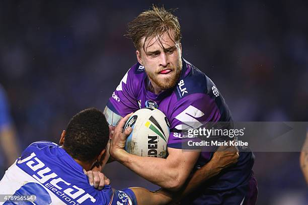 Cameron Munster of the Storm is tackled during the round 16 NRL match between the Canterbury Bulldogs and the Melbourne Storm at Belmore Sports...