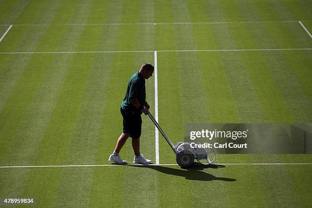 Groundsman paints a line on Centre Court on day 1 of the Wimbledon tennis tournament on June 29, 2015 in London, England. The 129th tournament to be...