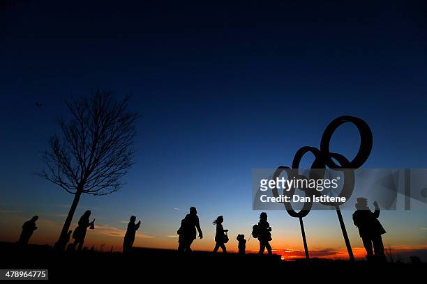 Cycling fans walk past the Olympic Rings at sunset inside the Olympic Park before attending Revolution 5 at the Velodrome in the Lee Valley Velopark...
