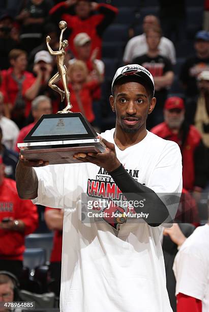 Russ Smith of the Louisville Cardinals holds up the MVP tournament trophy after defeating the Connecticut Huskies during the Championship of the...