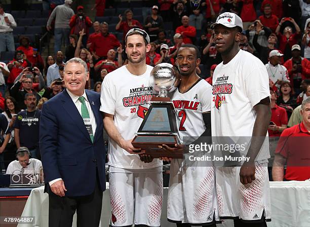 Mike Aresco, Commisioner of the AAC poses with Luke Hancock, Russ Smith and Montrezl Harrell of The Louisville Cardinals after presenting the...