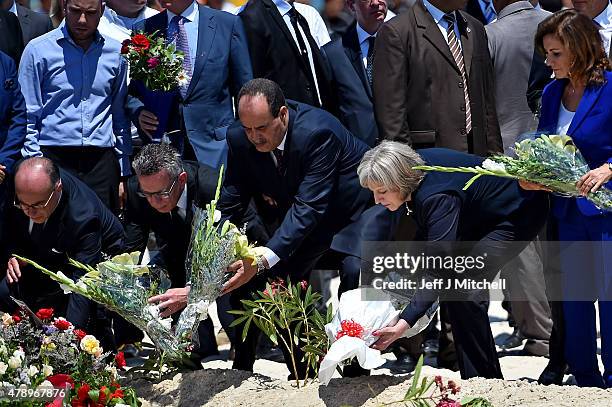 German Interior Minister Thomas de Maiziere , Tunisia's Interior Minister Mohamed Gharsalli and British Home Secretary Theresa May lay flowers at the...