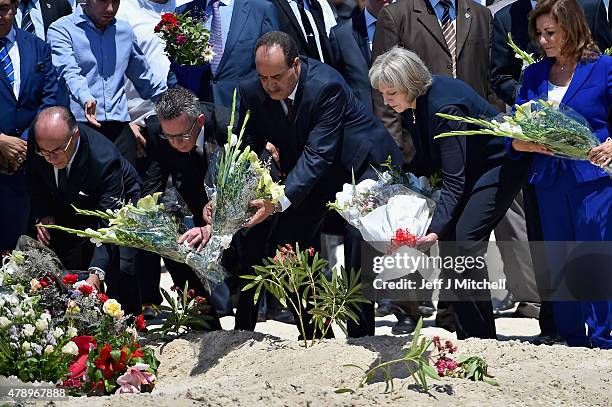 German Interior Minister Thomas de Maiziere , Tunisia's Interior Minister Mohamed Gharsalli and British Home Secretary Theresa May lay flowers at the...