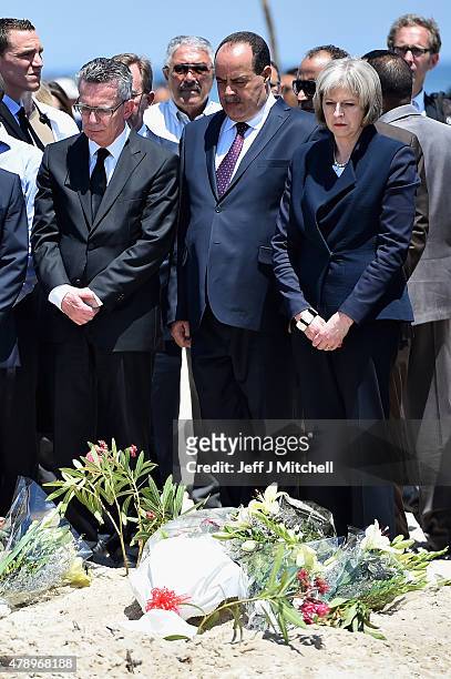 German Interior Minister Thomas de Maiziere , Tunisia's Interior Minister Mohamed Gharsalli and British Home Secretary Theresa May look on after...