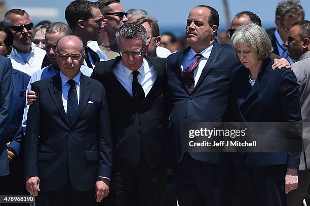 German Interior Minister Thomas de Maiziere , Tunisia's Interior Minister Mohamed Gharsalli and British Home Secretary Theresa May look on after...