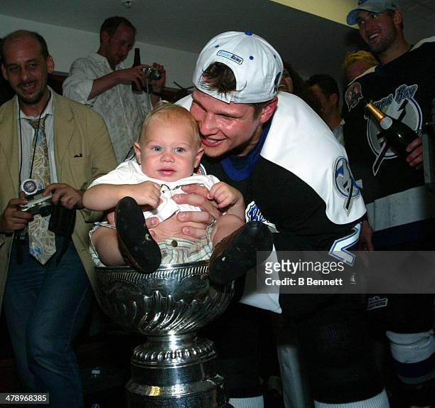 Stan Neckar of the Tampa Bay Lightning celebrates in the locker room with his son and the Stanley Cup after defeating the Calgary Flames in Game 7 of...