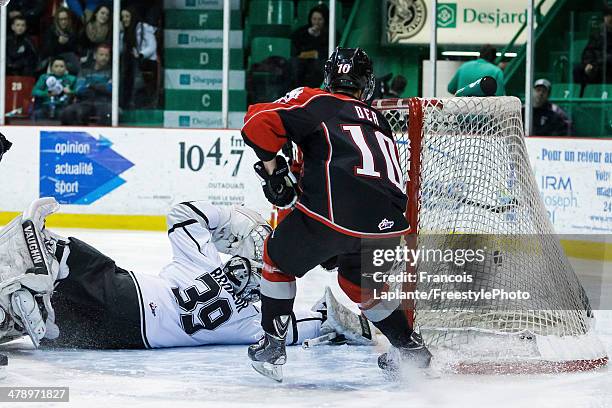 Jean-Sebastien Dea of the Rouyn-Noranda Huskies looks as the puck goes past goaltender Anthony Brodeur of the Gatineau Olympiques during the QMJHL...