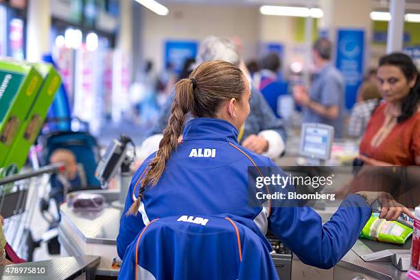 Member of staff prepares to scan goods taken from a customer's shopping basket at the check-out counter inside an Aldi supermarket store in London,...