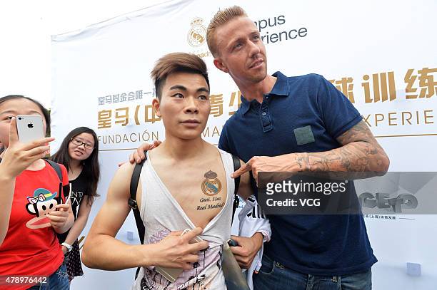 Jose Maria Gutierrez 'Guti'poses with a fan, who has a tattoo of Guti's name on his chest, as Real Madrid's Campus Experience opens on June 29, 2015...