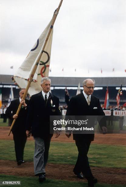 Summer Olympics: President of the Games Robert Menzies,carrying the Olympic flag, with chairman of the organizing committee Wilfrid Kent Hughes and...
