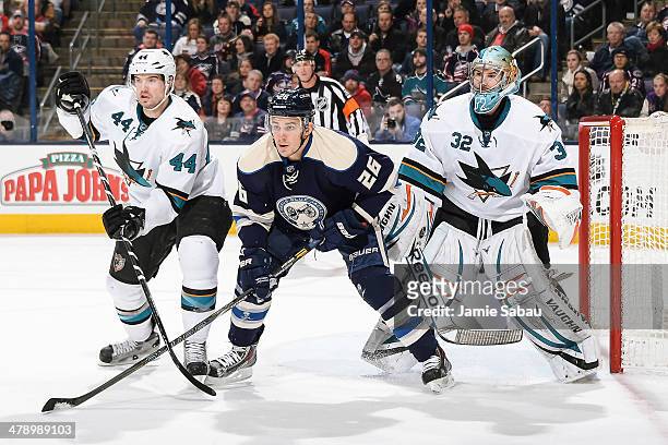 Marc-Edouard Vlasic of the San Jose Sharks and Corey Tropp of the Columbus Blue Jackets battle for position in front of goaltender Alex Stalock of...